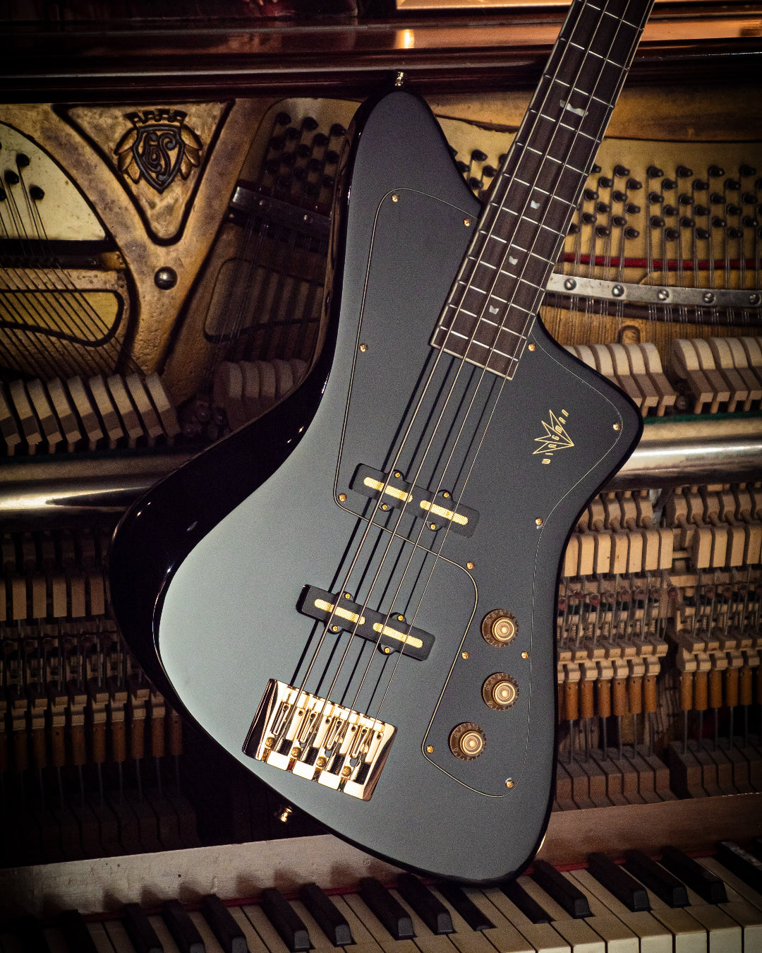 Pure Black Wingman electric bass guitar on a piano