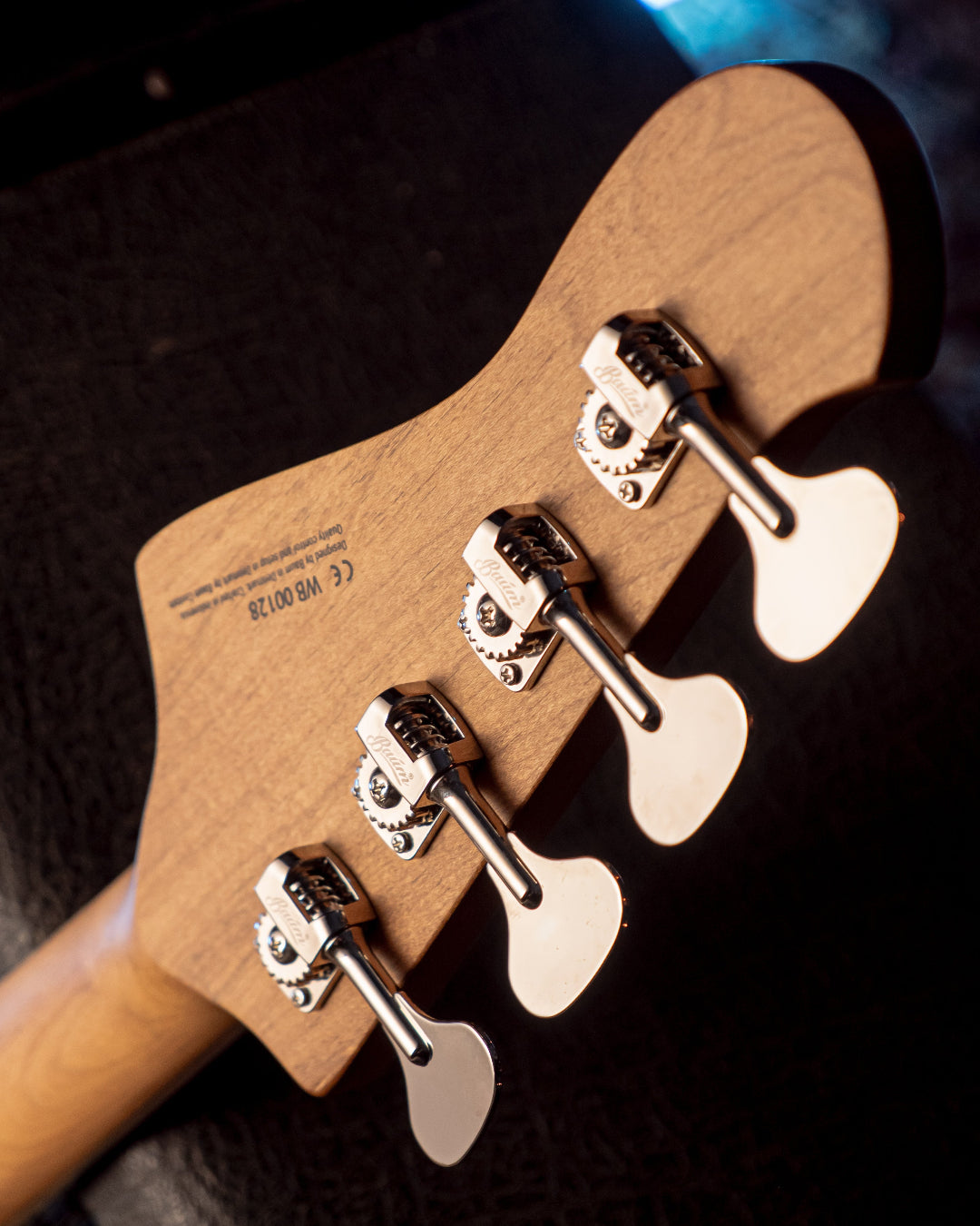 Close-up of a Baum Wingman bass tuning pegs with a dark background