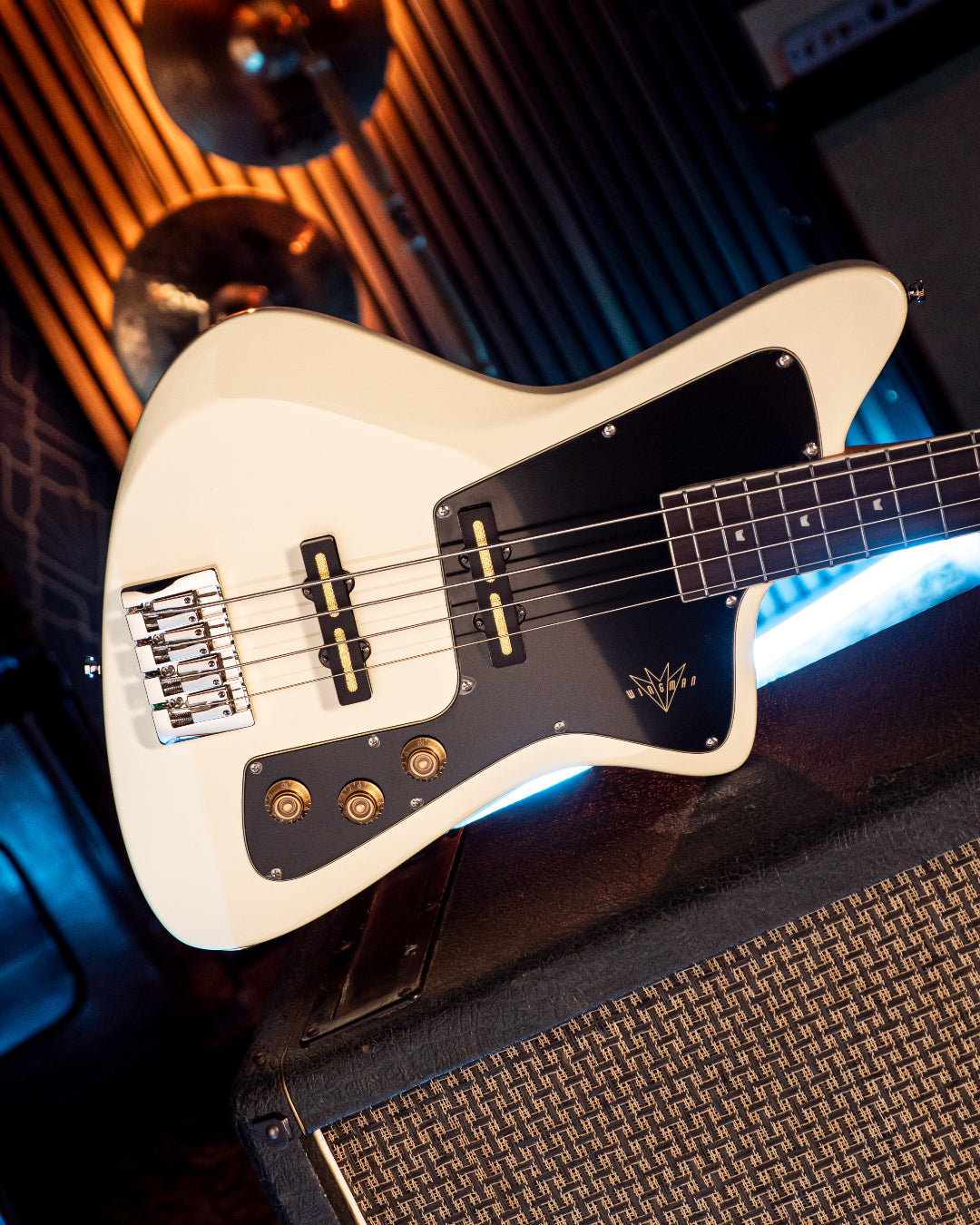 White Baum Wingman bass guitar with black pickguard on a dark background