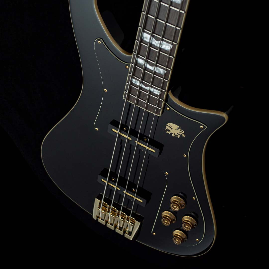 Black electric Baum bass guitar with gold hardware on a black background